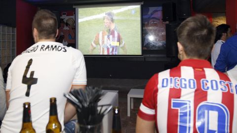 Dos j�venes ven un partido en un bar