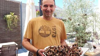 Diego Iglesias, organizador del campeonato, con una bandeja de percebes en la terra de su restaurante, el Bon P