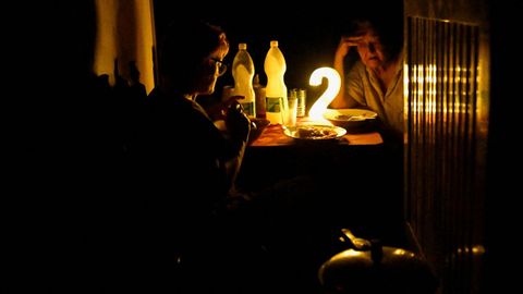 Dos mujeres cenan casi a oscuras en una vivienda de La Habana durante el �ltimo apag�n total, iniciado el s�bado