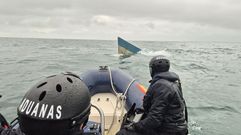 Un grupo de agentes del Servicio de Vigilancia Aduanera se acerca, en una lancha, al narco submarino hallado en las proximidades de Camari&ntilde;as a finales del mes de enero del a&ntilde;o pasado