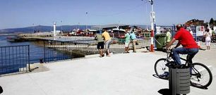 La instalaci�n de la batea de La Vuelta anima a vecinos y turistas a asomar por el puerto para ver y fotografiar la plataforma.