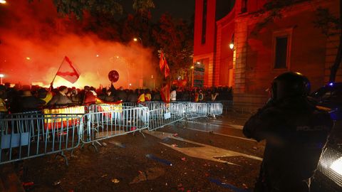 Manifestantes situados junto a la valla colocada por la Polica Nacional en uno de los accesos a la calle Ferraz de Madrid.