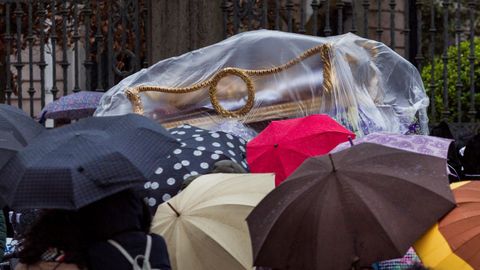  La imagen del Santo Cristo Yacente es cubierta con un plástico ante la lluvia que apareció y acortó el recorrido de la procesión del Santo Entierro, de la cofradia del Santo Entierro y Nuestra Señora de los Dolores, que se celebra hoy Viernes Santo en Oviedo dentro de los actos de la semana santa ovetense. 
