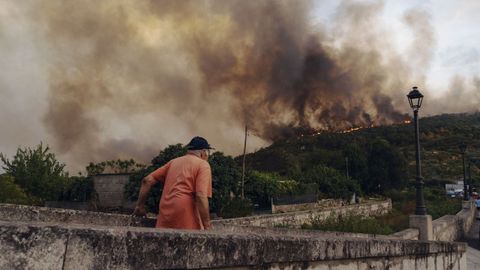 Un vecino de O&iacute;mbra, viendo el humo y las llamas del incendio el d&iacute;a que se origin&oacute;, el 12 de agosto.