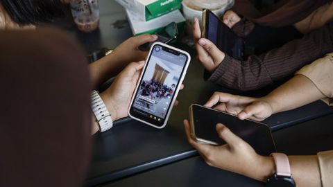 J&oacute;venes usando redes sociales en sus  m&oacute;viles.