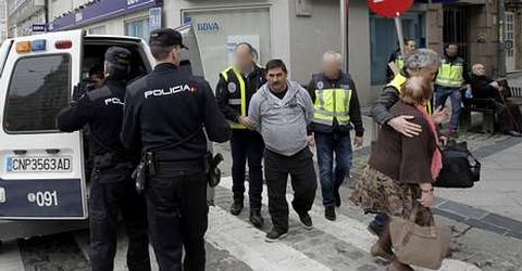 Agentes de la Polica Nacional trasladan a uno de los detenidos durante los registros.