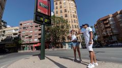  Dos j�venes beben agua junto a un term�metro que marca 43 grados cent�grados, este martes en la Plaza del Royo de Murcia