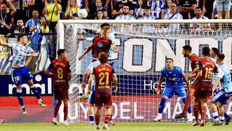 El deportivista Arnau Comas trata de rematar un crner botado al rea del Mlaga