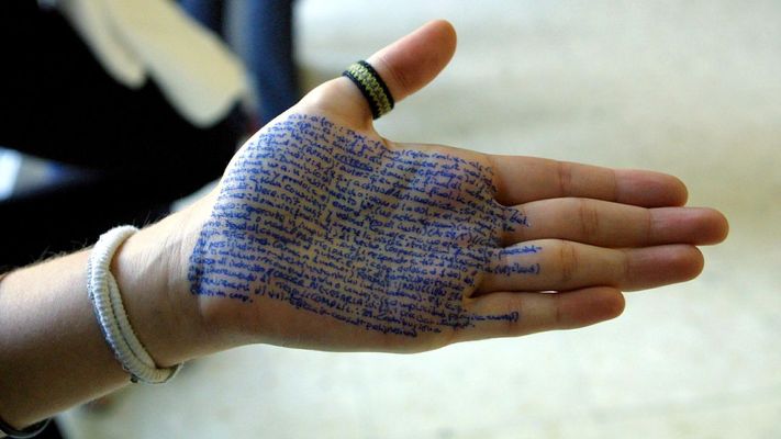 Un estudiante muestra una chuleta escrita con bol�grafo en la palma de su mano.
