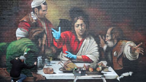 El artista Lionel Stanhope realiza un mural en Ladywell, en Londres, que lleva los guantes protectores a la �Cena de Ema�s� de Caravaggio