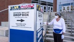 Una mujer depostia su voto anticipado en una oficina electoral de Maryland