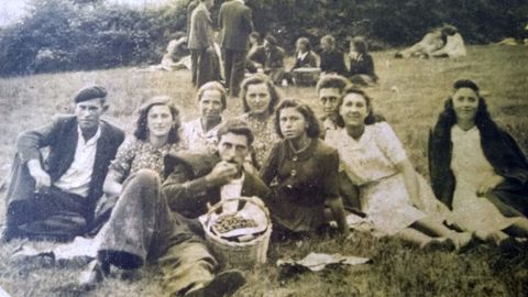 Un grupo de personascomiendo el bollo durantelas fiestas de San Antonio, en una imagen antigua