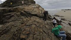 Pese a los avisos, la gente trepa a las rocas de As Catedrais, algo prohibido