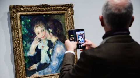 Un hombre saca una foto a la obra &laquo;Confidencia&raquo;, de Auguste Renoir. 