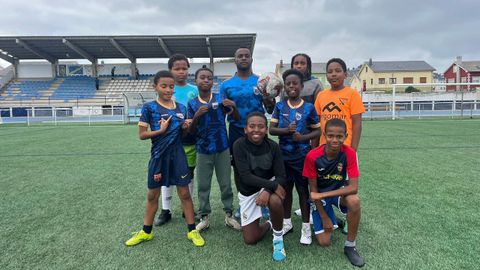 El edil en Burela Félix Martins, en el centro, en A Veiga junto a varios de los chavales de origen caboverdiano que entrena en el CD San Ciprián. Varios lucen la camiseta de su selección.