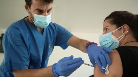 Un enfermero vacunando a una sanitaria en Barcelona con la vacuna de Pfizer