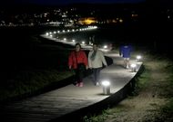 <span lang= es-es >Coroso</span>. La pasarela de madera que comunica el paseo de Coroso con el otro extremo del arenal est� iluminada con leds que, al estar en farolas bajas, aportan una claridad que gusta a los usuarios.