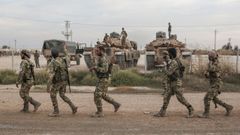 Milicianos sirios a los que apoya Ankara pasan por un campamento de tropas turcas