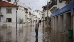 Un hombre observa c�mo el agua cubre sus tobillos en una calle de Alc�cer do Sal, en la regi�n de Set�bal.