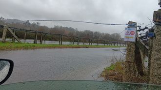 Imagen de la carretera que une Ponte Arnelas y Bai�n, cortada 2,5 kil�metros por el desbordamiento del r�o Umia.