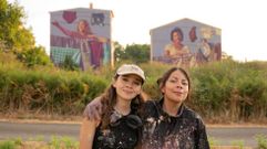 Las muralistas mexicanas Yuda (en la foto, con gorra) y Jan�n (con chaqueta) con las fachadas detr�s que pintaron cada una de ellas en el barrio de Conxo dentro de la �ltima edici�n del Delas Fest.