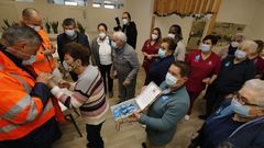 Los usuarios del centro de d�a Coidando de Vos, de Burela, entregan pins con �rboles de navidad hechos con elllos a miembros del comit� de Alcoa San Cibrao