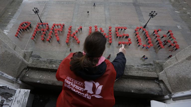 Enfermos de p�rkinson forman con paraguas el nombre de la enfermedad en la plaza de Mar�a Pita