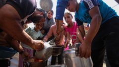 Palestinos recibe comida en la ciudad de Gaza.