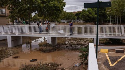 Varias personas pasan por un puente del barranco de La Saleta, en Aldaia (Valencia)