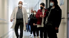 Un m�dico pasa junto a una fila de personas que esperan para vacunarse en el hospital de Monforte