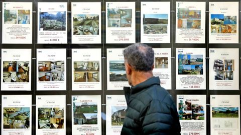 Un vecino de Vigo, delante de anuncios de venta de pisos.