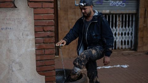 Un voluntario se limpia en una fuente en Benetússer 