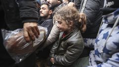 Una ni�a espera la ayuda que les prestan organizaciones humanitarias en un campamento frente a la frontera polaca.