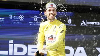 Adam Yates celebra el triunfo en el podio de O Gran Cami&ntilde;o 2026, ubicado en el monte Tegra.