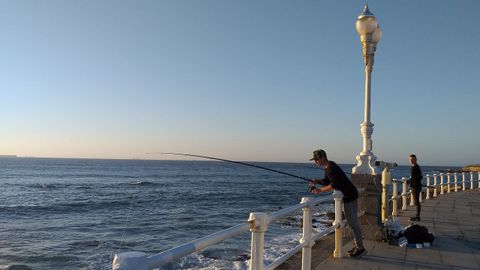 Pescador en el muro de San Lorenzo de Gijn