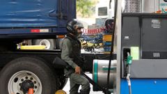 Un miembro de la Guardia Nacional Bolivariana vigila el abastecimiento de combustible en una estaci�n de servicio de Caracas
