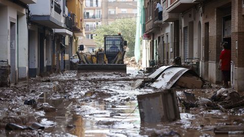  Una mquina escavadora retira el lodo acumulado en las calles