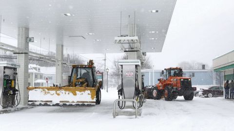 Dos m�quinas quitanieves repostan en una estaci�n de servicio