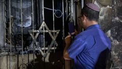 Un jud�o israel� observa los da�os en una sinagoga incendiada en la ciudad mixta de Lod