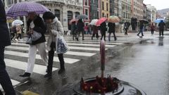 Un grupo de personas con paraguas en el centro de Oviedo