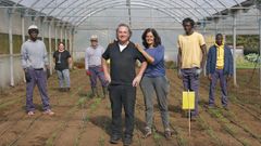 V�ctor Manuel, presidente de Ra��a, junto al resto del personal y j�venes acogidos por la asociaci�n en uno de los invernadores de la escuela de agricultura ecol�gica, en Vilasantar.