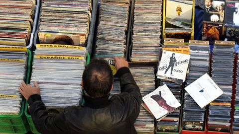 Hombre repasando vinilos en un mercado de Santiago.