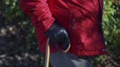 Hombre de edad avanzada con bast�n y guantes, en imagen de archivo