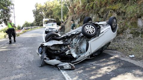 El coche en el que viajaba el conductor herido, volcado sobre la calzada.