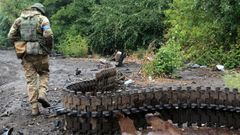 Un soldado ucraniano inspecciona los restos de un tanque ruso en la regi�n de J�rkov