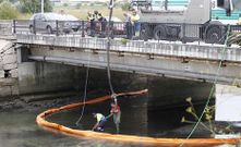Operarios de Segem limpiando el pasado lunes el vertido de la depuradora bajo el puente del Lagares en Samil.