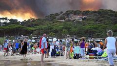 Gente en la playa observando el incendio en Francia