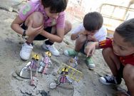Un grupo de ni�os juegan en Canido con un peculiar montaje escult�rico sobre las meninas, en la �ltima edici�n.