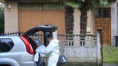 Un miembro de la Polic�a Cient�fica, frente a la casa donde mataron a un vecino de R�bade.