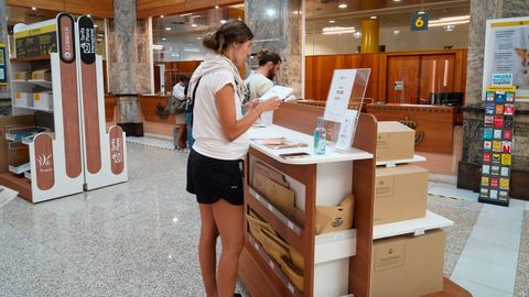 Una mujer lee las instrucciones para emitir el voto en oficina de A Corua